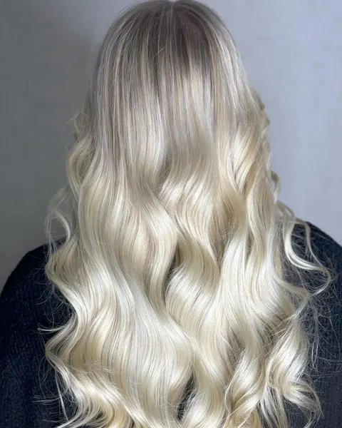 Langes Platinblond in großen Wellen mit dunklerem, weich auslaufendem Ansatz, von hinten